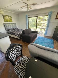 a living room with a bed and a couch at The Treehouse in Amanzimtoti