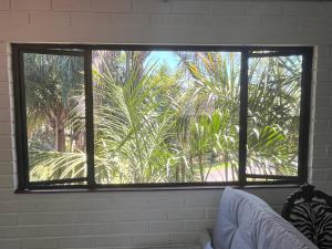 a window with a view of a palm tree at The Treehouse in Amanzimtoti