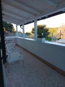 une rangée de chaises blanches assises sur un balcon dans l'établissement Case vacanze Leo & Cristina, à Peschici
