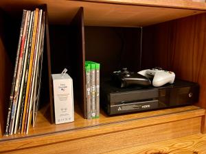 a shelf with video games and a nintendo wii controller at Villa Wargquist in Djuras