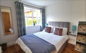 - une chambre avec un grand lit et une fenêtre dans l'établissement Ednyfed Apartment, à Nefyn