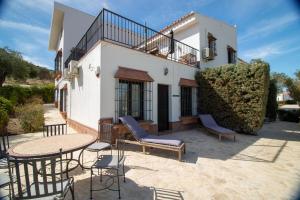 a patio with a table and chairs and a building at Villa Mantequilla in Alora