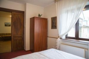 Kompleksowo wyposażony apartament w centrum في كراكوف: غرفة نوم بسرير وخزانة خشبية ونافذة