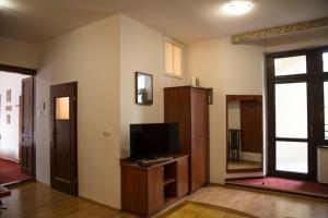 Kompleksowo wyposażony apartament w centrum في كراكوف: غرفة معيشة مع تلفزيون على منصة خشبية