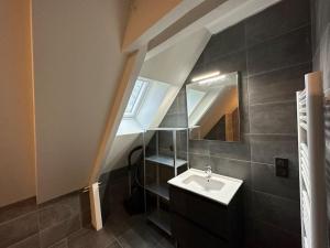 ein Bad mit einem Waschbecken und einem Spiegel in der Unterkunft une maison d'hôtes alliant charme et confort in Saint-Pierre-du-Val