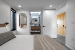 una camera da letto con un letto grande e uno specchio di Spruce - Luxury 1 Bdrm Cottage Stunning Views & Hot Tub, Private Path to the Beach a Margaree Harbour