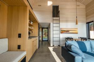 un soggiorno e una cucina in una casetta minuscola di Spruce - Luxury 1 Bdrm Cottage Stunning Views & Hot Tub, Private Path to the Beach a Margaree Harbour Altre 17 foto
