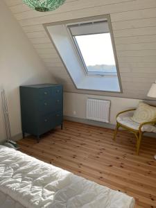 a attic bedroom with a bed and a window at Eternellgården in Kivik