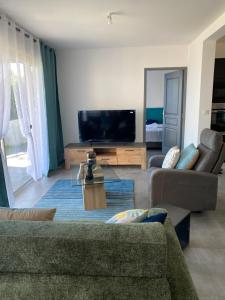 sala de estar con sofá y TV de pantalla plana en Villa Primo 2, en Le Lambert