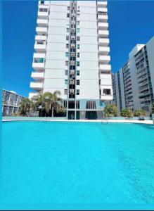a large swimming pool in front of a tall building at Paradise Palms in San Juan