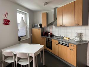 a kitchen with a white table and white chairs in it at Residenz Mühlenberg Typ A in Willingen
