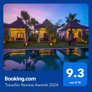 a villa with a swimming pool at night at Bali Mynah Villas Resort in Jimbaran