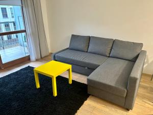 uma sala de estar com um sofá e um banco amarelo em Project Comfort Apartament Dywizjonu 303 149A/15 Warszawa em Varsóvia