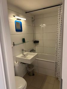 a bathroom with a sink and a toilet and a tub at Gemütliche Zimmer - Messe Gruga in Essen
