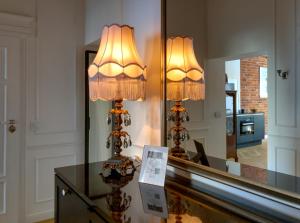uma lâmpada sobre uma mesa em frente a um espelho em Tom Sawyer’s 3 room Old Town Apartment em Breslávia