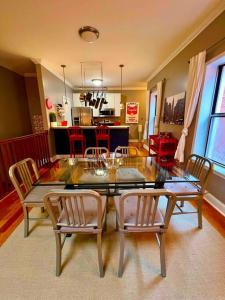a dining room with a glass table and chairs at Coolest condo ever- Indy's best at your door step - Central Mass Ave! in Indianapolis