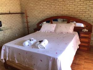 a bed with three rolls of toilet paper on it at Na Praia- Espaço Dom Artur in Araruama