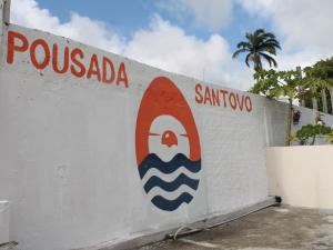 a white wall with a surfboard painted on it at Pousada Santovo in Porto De Galinhas