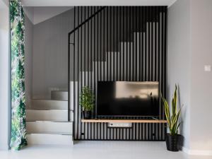a living room with a television and a staircase at Osada Nord domki wypoczynkowe in Jastrzębia Góra