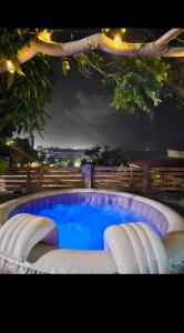 - une piscine entourée de trois chaises la nuit dans l'établissement BE BLUE GREEN, à Fort-de-France