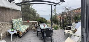 a patio with a table and chairs on a deck at Casa del sasso in Bergeggi