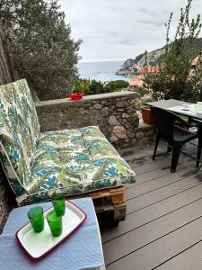 a patio with a couch and a table with glasses on it at Casa del sasso in Bergeggi