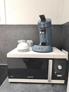 una macchinetta del caffè seduta sopra un forno a microonde di Studio entier proche des commerces - 1 à 2 pers - a Langon Altre 2 foto