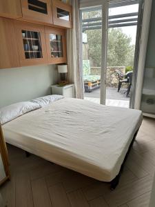 a large bed in a bedroom with a sliding glass door at Casa del sasso in Bergeggi