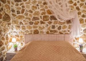 a bedroom with a stone wall with a bed at Bungalow nefeli in Agios Gordios