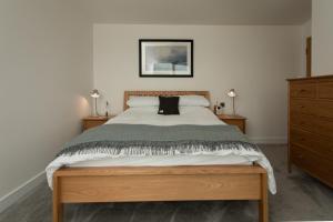 a bedroom with a large bed and two night stands at Rowan Cottage in Kensaleyre