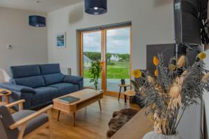 un soggiorno con divano blu e tavolo di Rowan Cottage a Kensaleyre