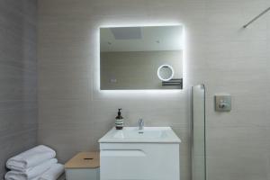 ein weißes Badezimmer mit Waschbecken und Spiegel in der Unterkunft Rowan Cottage in Kensaleyre + 28 Fotos