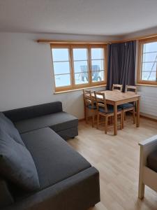 - un salon avec un canapé et une table dans l'établissement Zimmer in Adelboden, à Adelboden