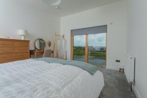 ein Schlafzimmer mit einem Bett, einer Kommode und einem Fenster in der Unterkunft Rowan Cottage in Kensaleyre