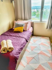 Bett in einem Zimmer mit Fenster in der Unterkunft Urban Oasis Condo Near Ayala Mall Centrio 2 in Cagayan de Oro