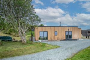 ein Holzhaus mit Kieseinfahrt in der Unterkunft Rowan Cottage in Kensaleyre