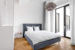 a white bedroom with a bed and a large window at Luxury apartment in the center in Prague