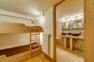 Cette chambre comprend des lits superposés et une cuisine. dans l'établissement Magnifique et Chaleureux Chalet à Val d'Isere, à Le Fornet