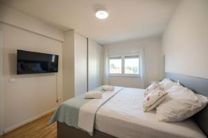 - une chambre avec un lit et une télévision murale dans l'établissement Apartment Karlo, à Trogir