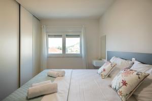 une chambre avec un grand lit avec deux oreillers dessus dans l'établissement Apartment Karlo, à Trogir