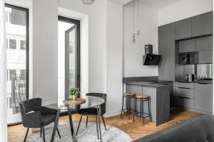 a kitchen and dining room with a glass table and chairs at Luxury apartment in the center in Prague
