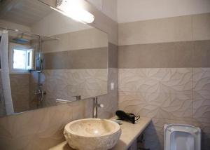 y baño con lavabo de piedra y ducha. en Bungalow nefeli en Agios Gordios