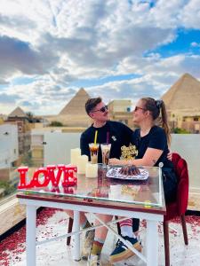 Un uomo e una donna seduti a un tavolo con una torta di Locanda pyramids view a Il Cairo