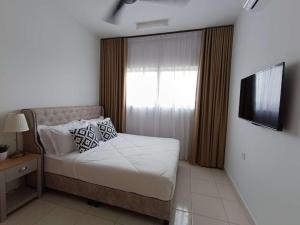 a small bedroom with a bed and a television at MamaQarl Homestay@KLIA&PICC+ Wi-Fi+Neflix 7pax in Sepang