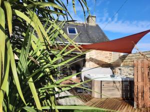 a red hammock hanging from the roof of a house at Gite avec spa sous les étoiles in Erbrée