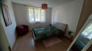 ChaponostにあるPlaisir des prés - Appartement T3, jardin, parkingのベッドと窓のある小さな寝室
