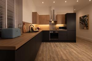 uma cozinha com armários de madeira e uma bancada em Lord Street Lofts em Southport