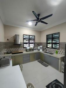 een keuken met een plafondventilator in een kamer bij Zahani Homestay in Kuala Terengganu