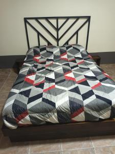 a bed with a black and white quilt on it at la pipi in Las Heras