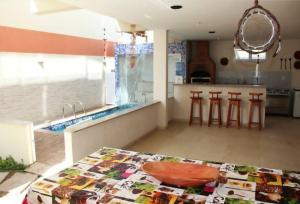 kuchnia ze stołem oraz kuchnia z blatem w obiekcie Solar de Manguinhos Flat w mieście Manguinhos
